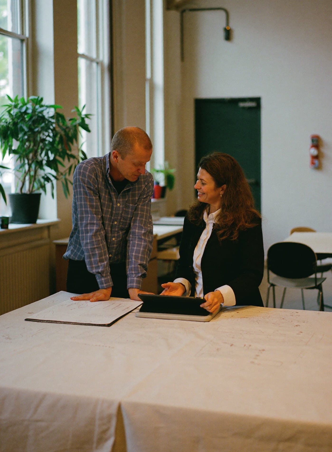 Twee partners van een installatiebedrijf bespreken tekeningen