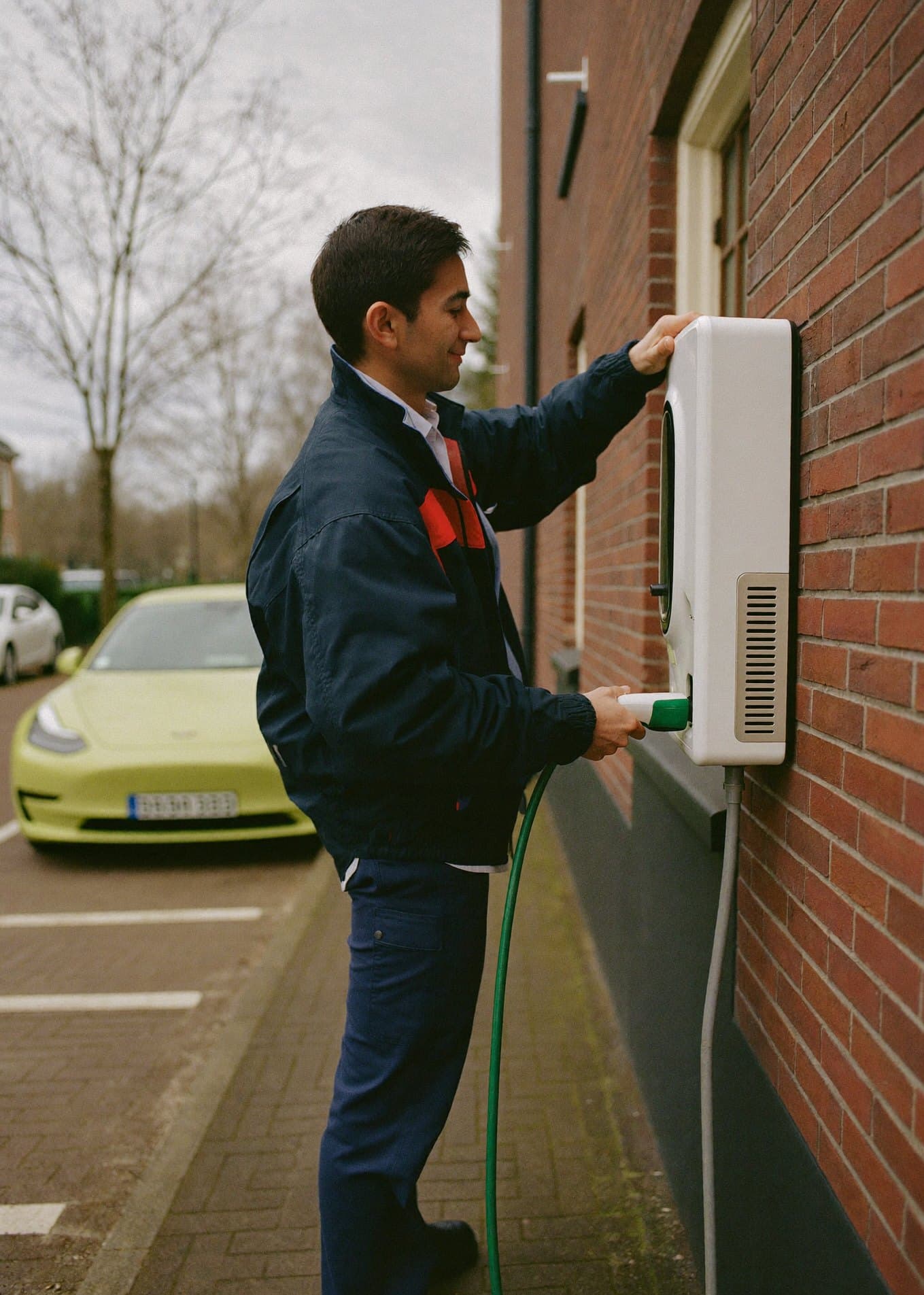 Monteur installeert een laadpaal aan een gevel